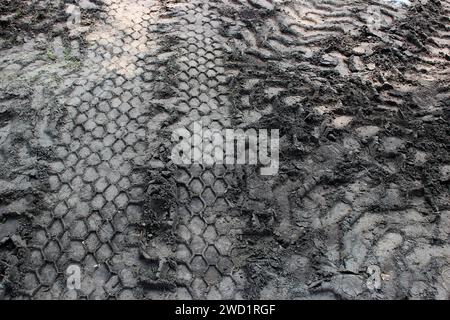 Segni intersecanti di veicoli da costruzione su fondo bagnato. Foto del concept stock per sfondi o design Foto Stock