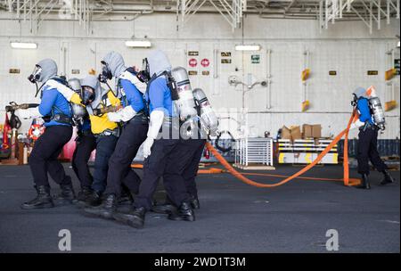 I marinai a bordo della portaerei USS Gerald R. Ford combattono un fuoco simulato durante un'esercitazione generale. Foto Stock