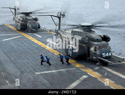 I marinai corrono verso la linea foul dopo aver terminato un'evoluzione a catena e cuneo su due elicotteri MH-53E Sea Dragon. Foto Stock