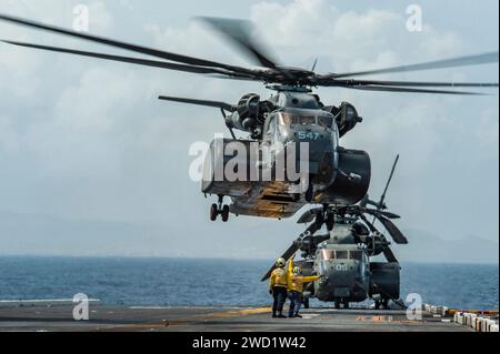 I marinai segnalano a un elicottero MH-53E Sea Dragon di decollare dalla USS Wasp. Foto Stock