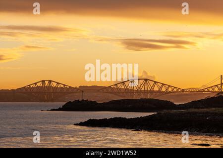 Un bellissimo tramonto sul Forth Bridge con Downing Point in primo piano, Dalgety Bay, Fife. Foto Stock