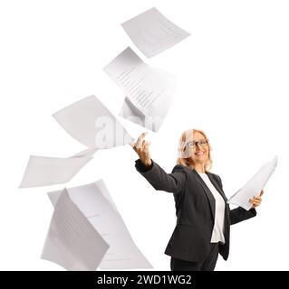 Felice donna di mezza età che lancia documenti cartacei e sorride isolata su sfondo bianco Foto Stock