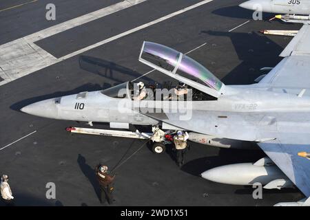 I marinai guidano un F/A-18F Super Hornet durante un'ispezione pre-volo sul ponte di volo della USS Theodore Roosevelt. Foto Stock
