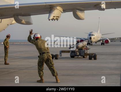 Aviation Ordnanceman dirige il carico di un missile arpione AGM-84D su un P-8A Poseidon. Foto Stock