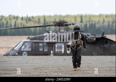 Un capo dell'equipaggio di elicotteri UH-60 Black Hawk dell'esercito degli Stati Uniti si avvicina al personale del raggio. Foto Stock