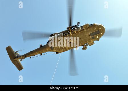 Un equipaggio di elicotteri UH-60 Blackhawk della Guardia Nazionale dell'Esercito si prepara a sollevare pararescuemen dell'Air Force. Foto Stock