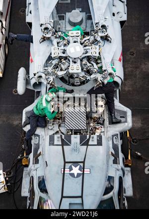 I marinai effettuano la manutenzione su un elicottero MH-60S Sea Hawk. Foto Stock