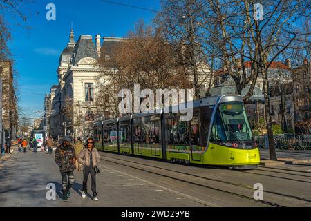 Il treno giallo della metropolitana leggera in piazza Jean Jaures in una giornata di sole con turisti e gente del posto a piedi. Saint-Étienne, Auvergne-Rhône-Alpes, Francia Foto Stock