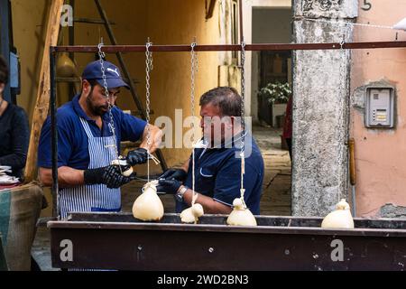 I venditori preparano il caciocavallo, detto Impiccato, alla festa, autunno a Ospedaletto d'Alpinolo, vicino ad Avellino, Italia Foto Stock