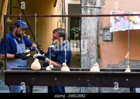 I venditori preparano il caciocavallo, detto Impiccato, alla festa, autunno a Ospedaletto d'Alpinolo, vicino ad Avellino, Italia Foto Stock