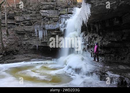 Summerhill Force, Teesdale, County Durham, Regno Unito. 18 gennaio 2024. Meteo Regno Unito. Gli escursionisti apprezzano lo spettacolo della cascata parzialmente ghiacciata di Summerhill Force, poiché le temperature rimangono ben al di sotto del congelamento a Teesdale, nella contea di Durham. Crediti: David Forster/Alamy Live News Foto Stock