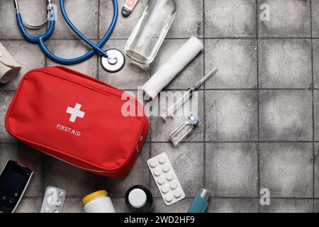 Kit di pronto soccorso con pillole su sfondo grigio grunge Foto Stock