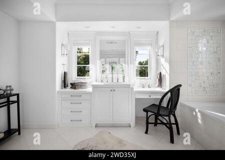 Bagno bianco vuoto con sedia e lavandino Foto Stock