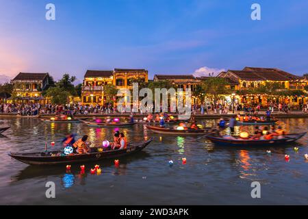 14 gennaio 2024: La gente cavalca le barche e rilascia lanterne di fiori di carta al fiume Thu Bon nell'antica città di Hoi An, in Vietnam di notte per pregare per la Be Foto Stock