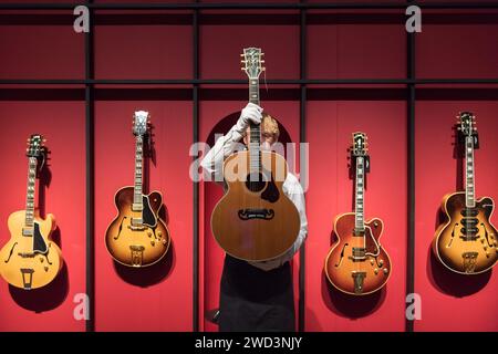 LONDRA, REGNO UNITO - 18 GENNAIO 2023: Un membro dello staff detiene Gibson Incorporated, Nashville, Tennessee, 1985, una chitarra acustica, J-200, Anniversary, Celebrity, Estimate: £5.000-7.000 durante una photocall alla casa d'aste di Christie's che mostra i momenti salienti della collezione personale di Mark Knopfler, frontman dell'iconica band britannica, dire Straits, a Londra, Regno Unito il 18 gennaio 2023. Le chitarre saranno offerte all'asta il 31 gennaio e il 25% del prezzo totale del martello sarà donato alle organizzazioni benefiche della Croce Rossa britannica, Tusk e Brave Hearts del Nord Est, che Mark K Foto Stock