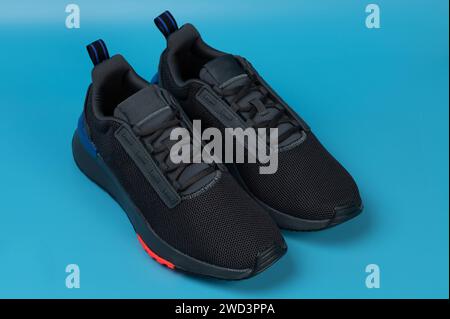 Scarpe da corsa sportive nere con lacci vista prospettica isolata su sfondo blu Foto Stock