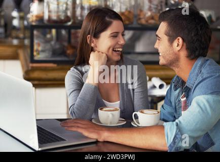 Conversazione con un computer portatile, un bar e una coppia che ridono dell'esperienza del cliente, della discussione o dello scherzo divertente del ristorante. Freelance, computer e persone sorridono Foto Stock