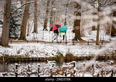 Ein Paar mit bunten Regenschirmen läuft m verschneiten Tiergarten a Berlino am 5. Januar 2024. Schneefall a Berlino *** Una coppia con ombrelloni colorati cammina nel nevoso Tiergarten a Berlino il 5 gennaio 2024 Foto Stock