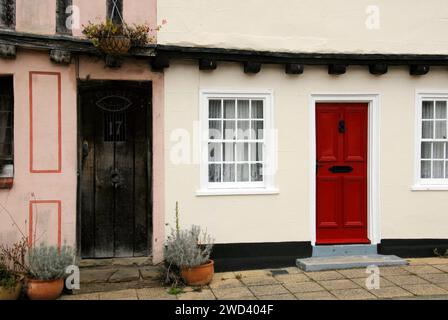 Parte di antiche case a schiera, una con porta rossa brillante, Beccles, Suffolk, Inghilterra Foto Stock