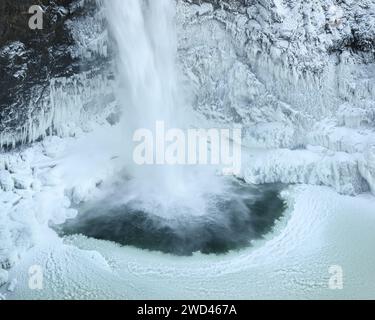 Cascata che si tuffa nella piscina ghiacciata in inverno durante il freddo alle Snoqualmie Falls Foto Stock