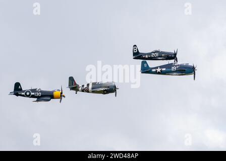 Gli aerei da caccia americani della seconda guerra mondiale volano in stretta formazione nel cielo. F4U corsair, F8F Wildcat, F4F tra gli altri. Foto Stock