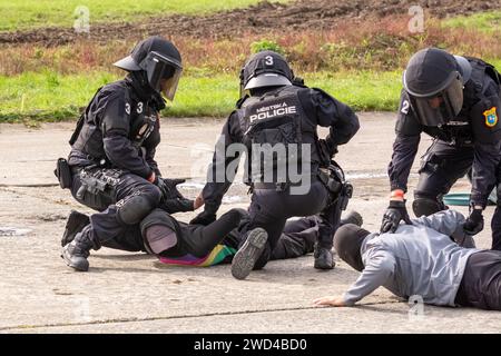 Agenti di polizia che arrestano i manifestanti durante una rivolta. La polizia di città della Repubblica Ceca městská policie in uniforme tattica durante una manifestazione a Ostrava. Foto Stock