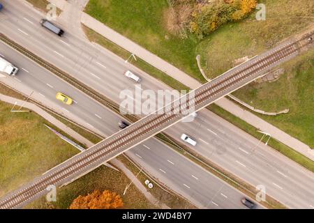 Fotografia con droni del ponte ferroviario che attraversa l'autostrada durante il soleggiato giorno autunnale Foto Stock