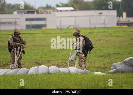 Paracadutisti delle forze speciali polacche (JW AGAT) che atterrano con paracadute su un aeroporto europeo dopo aver eseguito un salto HALO da un elicottero nel cielo. Foto Stock