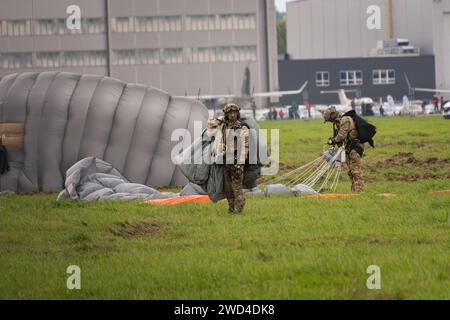 Paracadutisti delle forze speciali polacche (JW AGAT) che atterrano con paracadute su un aeroporto europeo dopo aver eseguito un salto HALO da un elicottero nel cielo. Foto Stock