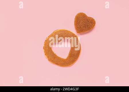 Composizione creativa con pasticceria per San Valentino su sfondo rosa Foto Stock