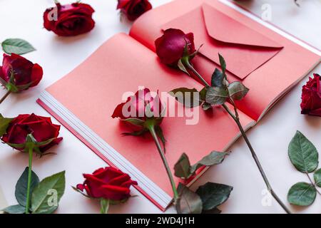 Una scena vivace di un notebook, una penna e fiori sul tavolo Foto Stock
