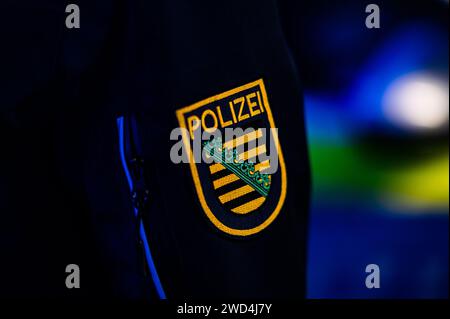 Dresda, Germania. 18 gennaio 2024. Un poliziotto sta accanto a un'auto della polizia. Credito: Robert Michael/dpa/Alamy Live News Foto Stock