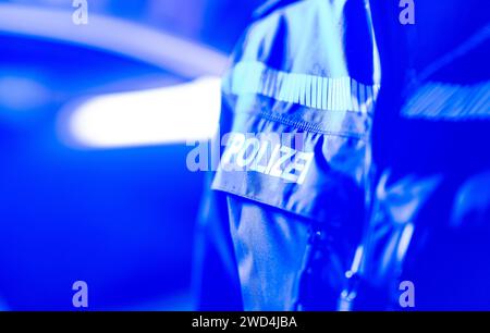 Dresda, Germania. 18 gennaio 2024. Un poliziotto sta accanto a un'auto della polizia. Credito: Robert Michael/dpa/Alamy Live News Foto Stock