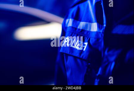 Dresda, Germania. 18 gennaio 2024. Un poliziotto sta accanto a un'auto della polizia. Credito: Robert Michael/dpa/Alamy Live News Foto Stock