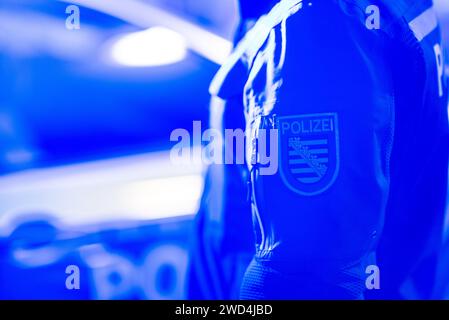 Dresda, Germania. 18 gennaio 2024. Un poliziotto sta accanto a un'auto della polizia. Credito: Robert Michael/dpa/Alamy Live News Foto Stock