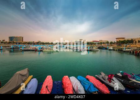 Golden Hour Harbor: Cattura la tranquilla bellezza dell'alba nel cantiere nautico di Fanateer Beach, al Jubail City, Arabia Saudita Foto Stock