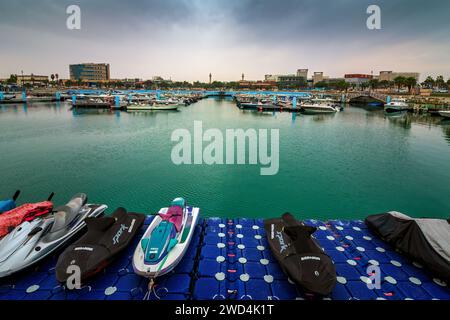 Golden Hour Harbor: Cattura la tranquilla bellezza dell'alba nel cantiere nautico di Fanateer Beach, al Jubail City, Arabia Saudita Foto Stock