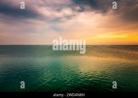 Golden Hour Harbor: Cattura la tranquilla bellezza dell'alba a Fanateer Beach, al Jubail City, Arabia Saudita. Foto Stock