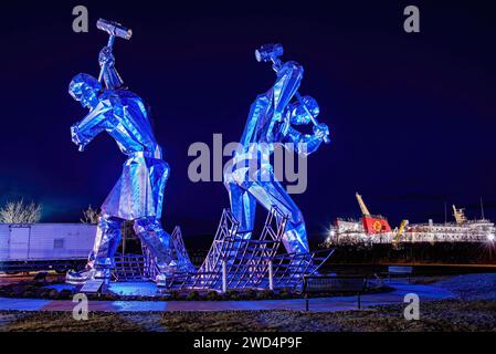 Scultura gigantesca dei costruttori navali al parco di Coronation a Inverclyde scattata alla notte. Foto Stock