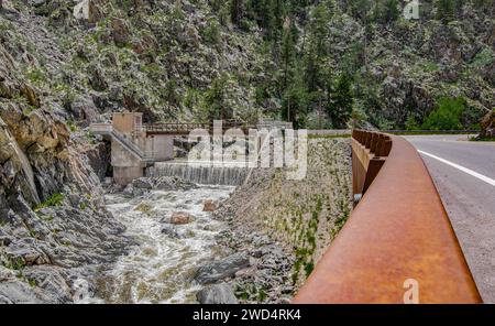 Dam on a Mountain Stream: Il fiume Thompson cade su una piccola diga e continua il suo percorso accanto a una strada di montagna nel nord del Colorado. Foto Stock