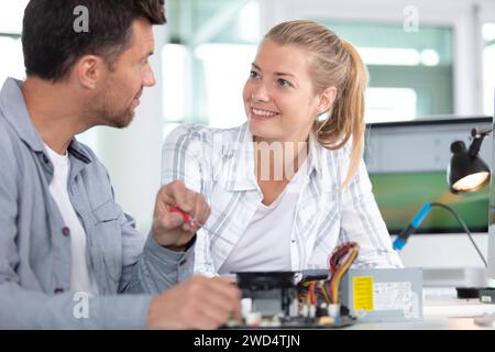 giovane attraente studente e insegnante di meccatronica che lavora al progetto Foto Stock