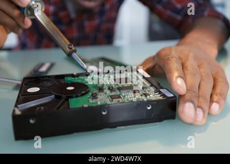componenti a saldare per mani maschili su una scheda a circuito stampato Foto Stock