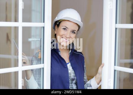 costruttore femminile che fissa una finestra Foto Stock