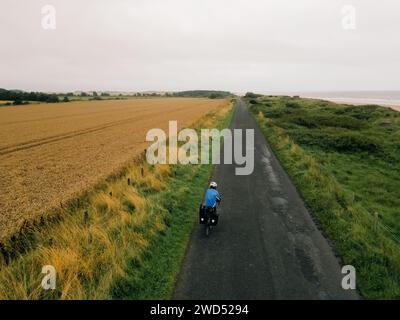 Foto aerea di una ciclista donna che attraversa campi in Inghilterra. Foto di alta qualità Foto Stock