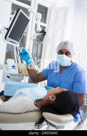 Dentista che mostra raggi X al paziente in clinica medica Foto Stock