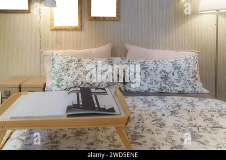 Accogliente camera da letto adornata da una lampada soffice che diffonde una luce calda e invitante. Questa scena rappresenta un rifugio sereno, perfetto per rilassarsi e abbracciare Foto Stock