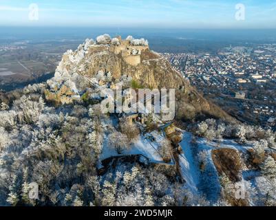 Vista aerea del vulcano innevato di Hegau Hohentwiel, con le rovine del castello più grandi della Germania, circondato da alberi ghiacciati in un paesaggio invernale, con Foto Stock