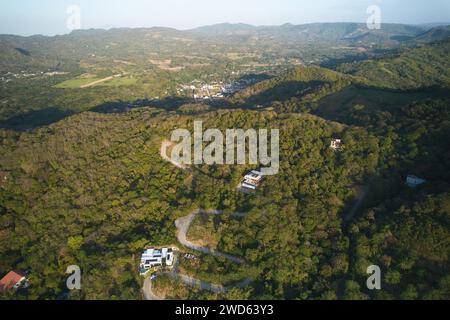 Grandi case sulle verdi colline con vista aerea dei droni al tramonto Foto Stock