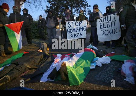 Gli attivisti si stendono sul terreno ghiacciato collegato l'uno all'altro con blocchi di metallo nel mezzo della strada durante la dimostrazione. Palestine Action e i loro sostenitori bloccano l’unica porta di Elbit Systems. Hanno una campagna in corso per chiudere la compagnia di difesa israeliana Elbit Systems nel Regno Unito. Hanno chiuso con successo due dei loro dieci siti originali con un'azione diretta ripetitiva. Sostengono che la società produce droni che sono responsabili di molte morti Palestinianís a Gaza e altrove. (Foto di Martin Pope/SOPA Images/Sipa USA) Foto Stock