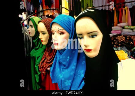 Una fila di manichini davanti a un venditore di abbigliamento islamico femminile in un centro commerciale di fronte alla moschea Daarut Tauhiid a Gegerkalong, Bandung, Giava Occidentale, Indonesia. Fondata dal famoso predicatore islamico indonesiano KH Abdullah Gymnastiar, Daarut Tauhiid e il suo ramo di gestione Manajemen Qolbu (mq) sono riusciti a intensificare il turismo religioso e le attività economiche nell'area di Gegerkalong nella città di Bandung. Foto Stock